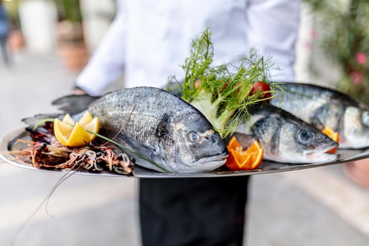 Lighthouse Golf & Spa Hotel Baltsjik Buitenkant foto A waiter holding a platter of fish